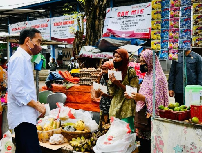 BLT minyak goreng Presiden Jokowi berbincang dengan warga seusai menyerahkan kartu BLT minyak goreng, sebagai subsidi atas melonjaknya harga minyak sawit. Mulai 28 April 2022, pemerintah mulai melarang eskpor minyak sawit. Foto: Setpres.