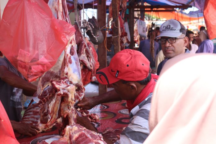 Seorang pedagang daging sedang memotong sie makmeugang yang dipesan pembeli di Terminal Matangglumpangdua, Minggu (1/5/2022). Foto:Komparatif.id/Riski Aulia Ramadan.