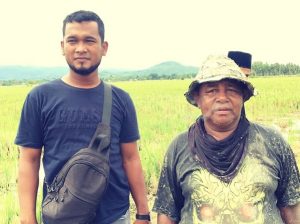 Waliyul Hidayah (kiri) dan seorang petani ketika sedang melihat proses pembajakan sawah menggunakan traktor milik kelompok tani Japakeh. Foto: ist.