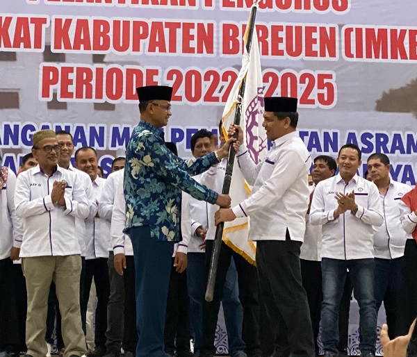 IMKB-lantik Bupati Bireuen (kiri) Dr. H. Muzakkar A. Gani, menyerahkan pataka IMKB kepada Zaini Yusuf. Pada kesempatan itu Bupati juga menyerahkan sumbangan Rp10 juta untuk kegiatan pelantikan tersebut. Foto: ist.