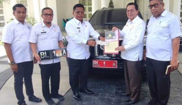 amin-dum-mobil Aminullah Usman (kiri) menerima dokumen Toyota Prado yang didum Rp200 juta. Saat dibeli, harga mobil tersebut Rp1,6 miliar rupiah. Foto: Humas Pemko Banda Aceh.