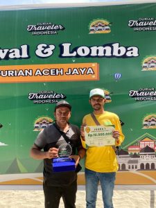 Adi (kiri) dan Muhammad Amin (kanan) saat berfoto memamerkan piala dan jumlah ahdiah. Foto: Ist.