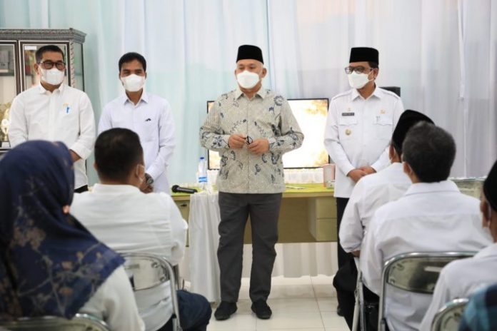 Sekda Aceh Taqwallah didampingi Pj Bupati Aceh Utara Azwardi Abdullah membagikan obat dalam rangka pelaksanaan GISA di SMAN 6 Lhokseumawe. Foto: Ist.