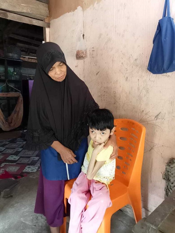 Uswatun Hasanah (kanan) saat didudukkan di kursi plastik, Minggu (2//10/2022). Foto: Fakrurrazi untuk Komparatif.id.