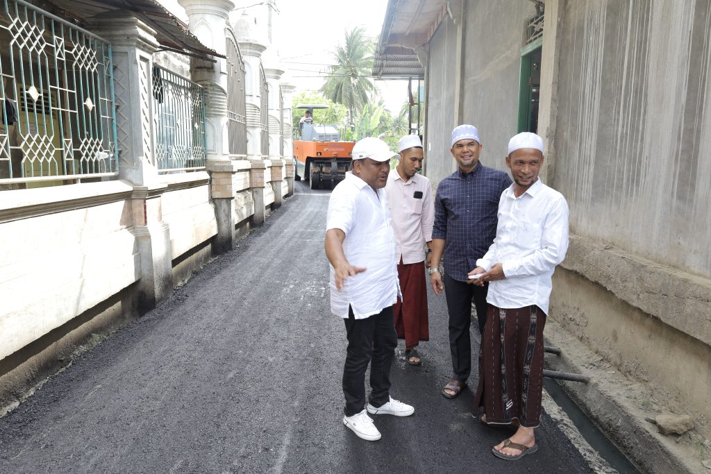 H. Mukhlis A.Md, mengaspal jalan menuju maqbarah (kuburan) Teungku H. Muhammad Amin bin Teungku Mahmud atau akrab disapa Tu Min