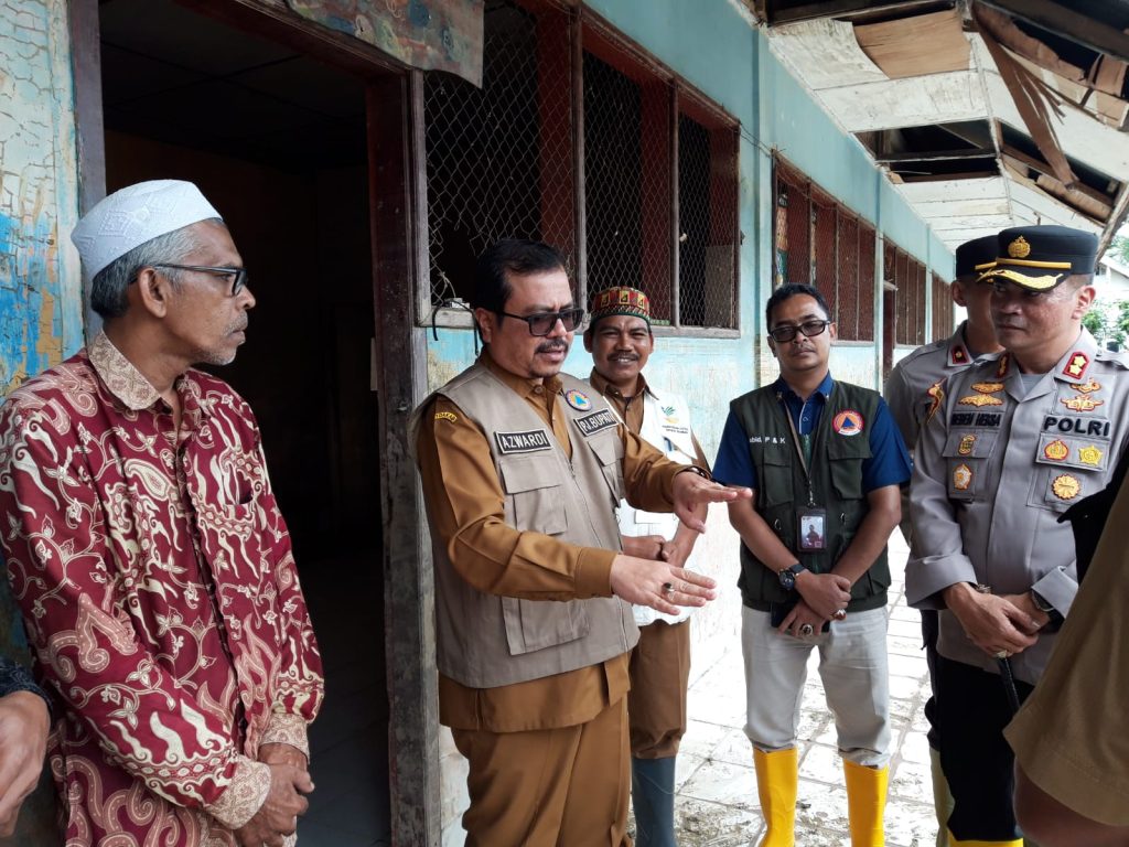 dayah Pj Bupati Aceh Utara Azwardi Abdullah (tengah) menjelaskan kondisi terkini perihal penanganan banjir. Kapolres Aceh Utara AKBP Deden Heksaputra (kanan) dan Abi Muslim (kiri) mendengarkan penjelasan tersebut, Selasa (24/1/2023). Foto: Komparatif.id/Muhajir Juli.