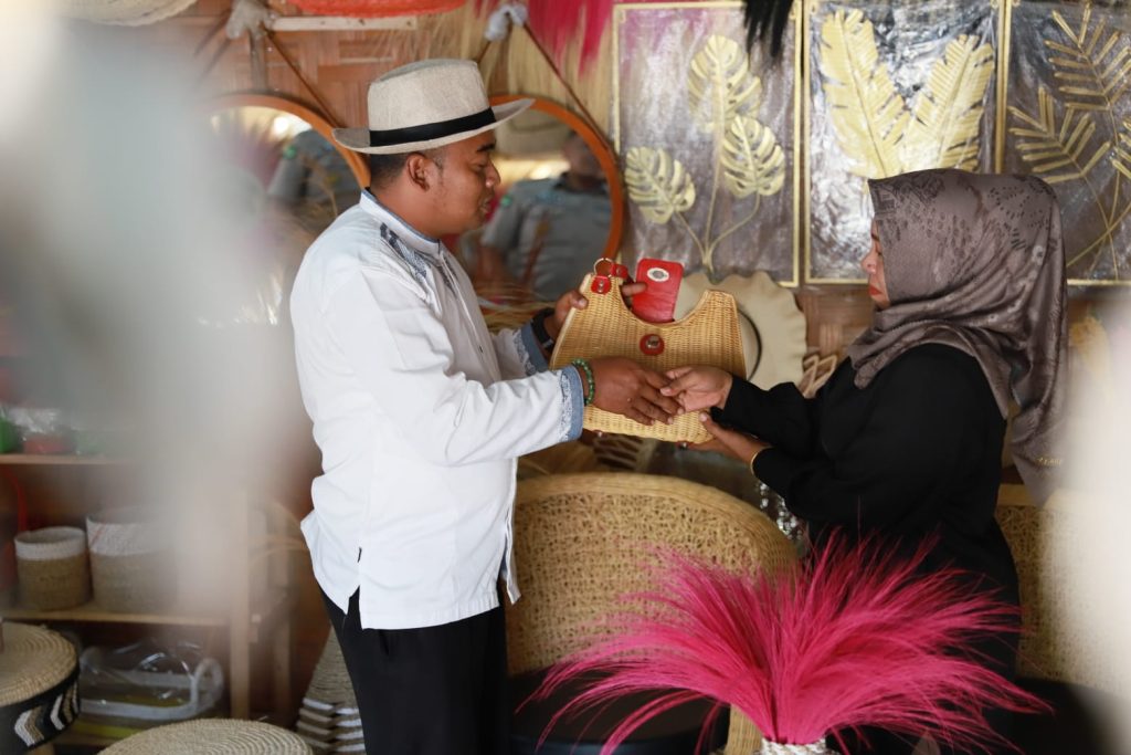 Nasabah UMKM Binaan Bank Aceh, Aminah, Melayani Pembeli di Toko Kerajinan Rotan Miliknya, Dua Saudara, yang Berada di Kecamatan Lhoknga, Kabupaten Aceh Besar, Jumat (23/02/2023).