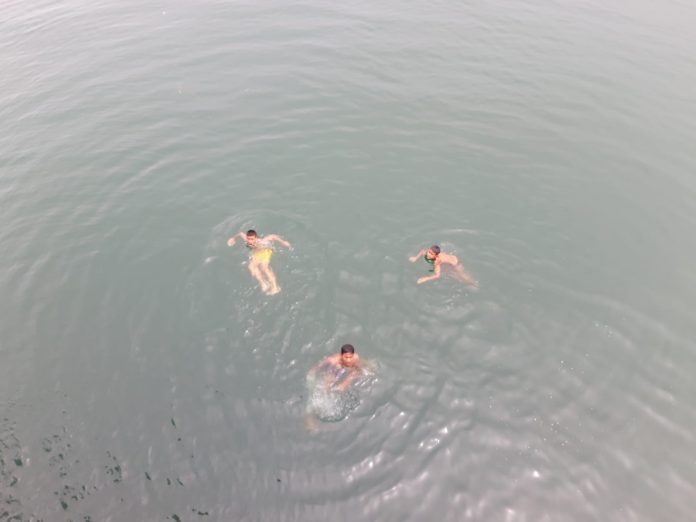 Tomok Tiga orang anak di Pelabuhan Tomok menunggu Rupiah yang dilemparkan penumpang KMP Tao Toba II, Senin (6/2/2023). Foto: Komparatif.ID/Muhajir Juli.