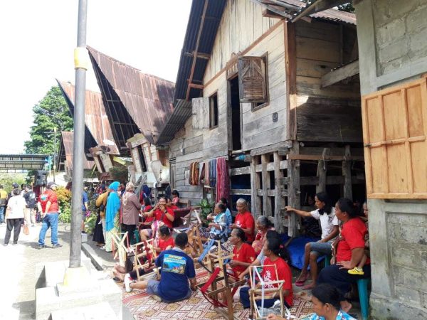 Secara tradisional ulos ditenun di kolong rumah masing-masing. Seiring perubahan zaman, tempat menenun ulos juga berubah. Kini ada yang membuat tempat khusus di depan rumah. Foto: Komparatif.id/Muhajir Juli.