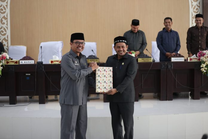 Pj Bupati Aceh Utara menyerahkan LKPJ Tahun Anggaran 2022 pada rapat Paripurna ke-2 Masa Persidangan I DPRK Aceh Utara Tahun 2023, Rabu (29/3/2023) malam. Foto: Humas/Muzakkir.