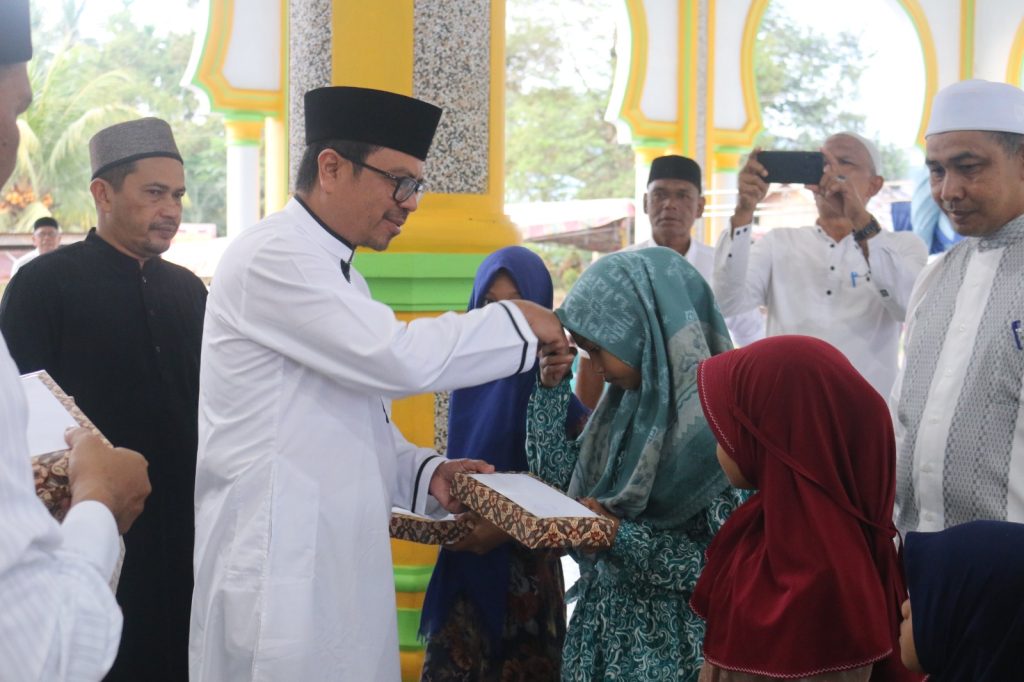 Pj Bupati Aceh Utara Azwardi Abdullah menyerahkan santunan untuk anak yatim di Gampong Riseh Tunong, Sawang, Rabu (28/3/2023). Foto: Komparatif.ID/Fuad Saputra.