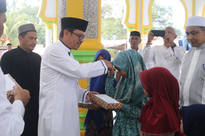 Pj Bupati Aceh Utara Azwardi Abdullah menyerahkan santunan untuk anak yatim di Gampong Riseh Tunong, Sawang, Rabu (28/3/2023). Foto: Komparatif.ID/Fuad Saputra.