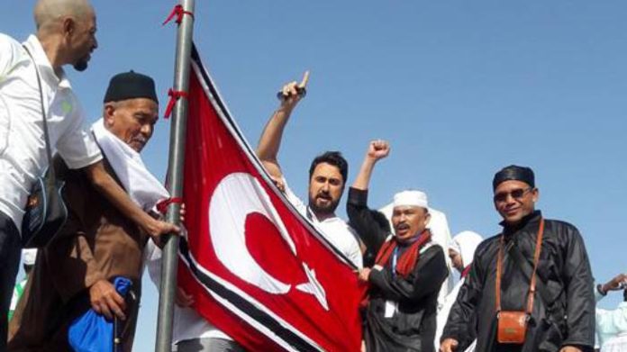 Pangliam GAM, TGK Zulkarnaini bin Hamzah atau Tgk Ni mengibarkan bendera Bintang Bulan di Jabal Rahmah, Mekkah, Arab Saudi. Foto ini diunggah di media sosial Facebook oleh pemilik akun Muqaddis Agam, Selasa (22/3). Disalin via Serambi Indonesia