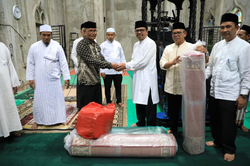 Pj Bupati Aceh Utara Azwardi Abdullah menyerahkan bantuan untuk masyarakat di Masjid Baiturrahman, Gampong Alue Ie Puteh, Baktiya, Kamis (30/3/2023). Foto: Humas/Muzakkir.