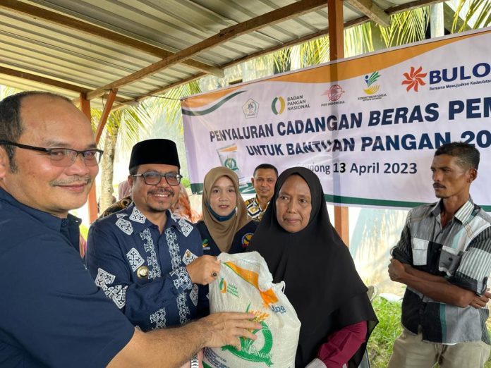 Pj Bupati Aceh Utara Azwardi Abdullah saat menyerahkan secara simbolis bantuan pangan cadangan beras pemerintah (BP-CBP) di Samudera, Kamis (13/4/2023). Foto: Humas.