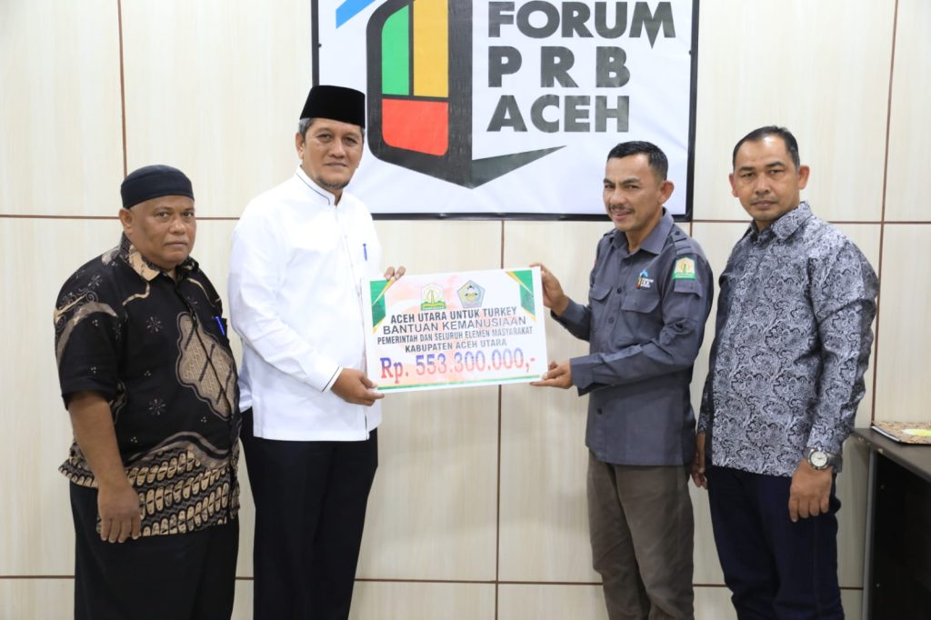 Asisten I Setdakab Aceh Utara Dayan Albar saat menyerahkan sumbangan untuk bencana gempa Turki-Suriah kepada BPBA di Banda Aceh, Selasa (11/4/2023). Foto: HO for Komparatif.ID.