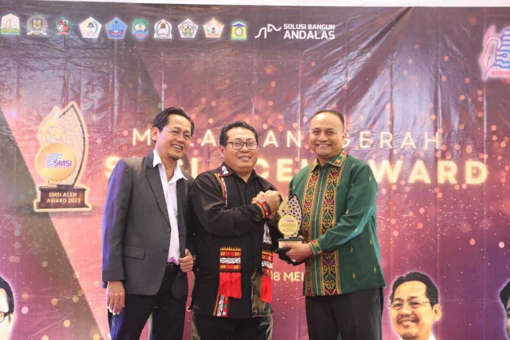Pj Wali Kota Lhokseumawe Dr.Drs. Imran, M.Si,MA.Cd saat menerima penghargaan SMSI Aceh Award 2023 sebagai Pemimpin Daerah Peduli UMKM dan Perkembangan Ekonomi. Foto: Komparatif.ID/Fuad Saputra.