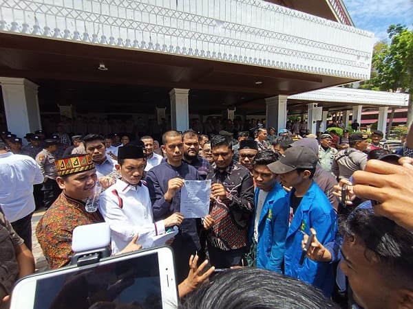 Ketua Banleg Mawardi bersama beberapa anggota DPRA memegang surat berisi tuntutan aksi massa. Foto: Komparatif.ID/Fuad Saputra.