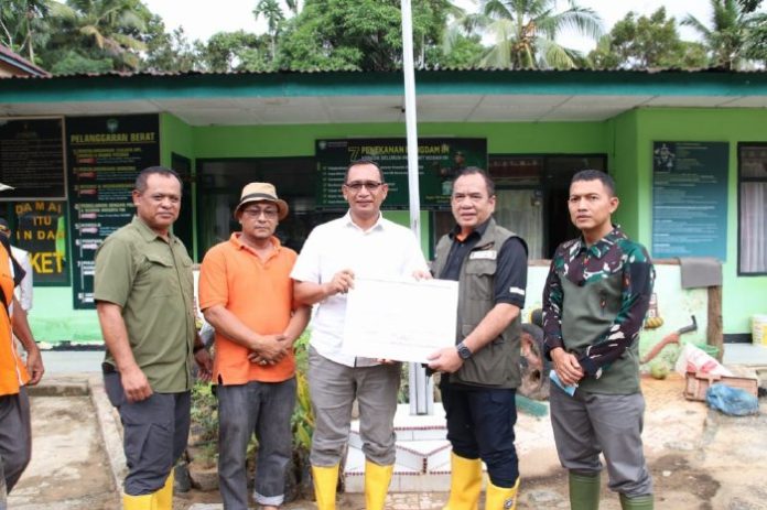 Deputi Rehabilitasi dan Rekonstruksi BNPB Jarwansyah menyerahkan dana siap pakai secara simbolis untuk penanganan banjir bandang di Aceh Selatan. Foto: Humas.