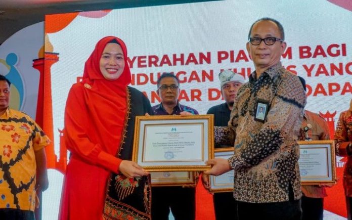 Kepala SLB TNCC DM Ria Hidayati saat menerima plakat penghargaan LPKRA dari Kementerian PPPA di Hotel Oria, Jakarta, Selasa (21/11/2023). Foto: Ho for Komparatif.ID.