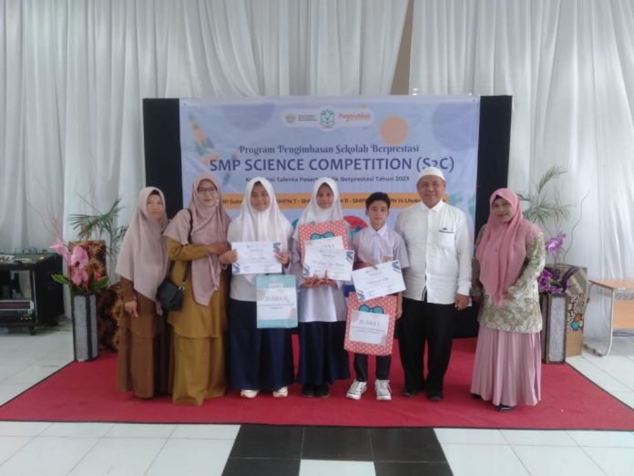 Tim S2C SMPN 9 Lhokseumawe berfoto bersama Kepala Sekolah dan guru pembimbing usai pengumuman juara, Rabu (28/11/2023). Foto: Komparatif.ID/Muzakkir.