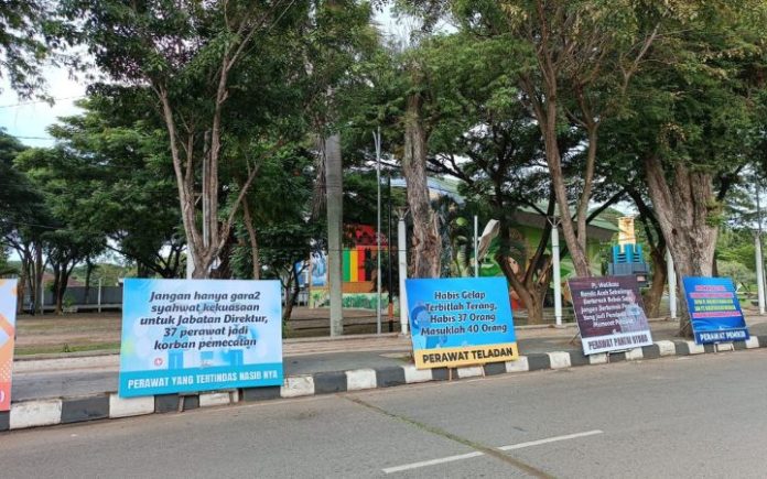 Puluhan papan bunga berjejer di depan Balai Kota Banda Aceh yang berisi tuntutan melakukan pemanggilan kembali terhadap 37 perawat RSUD Meuraxa yang dipecat tanpa syarat apapun, Senin (18/12/2023). Foto: Komparatif.ID/Fuad Saputra.