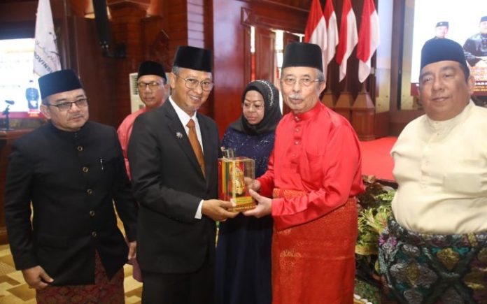 Pemerintah Aceh Komit Dukung Program Dunia Melayu Dunia Islam Asisten III Setda Aceh Iskandar saat menyerahkan cinderamata kepada Presiden Dunia Melayu Dunia Islam (DMDI) Tun Sri Setia (DR) H Mohd Ali bin Mohd Rustam, Selasa (16/1/2024). Foto: Ho for Komparatif.ID.