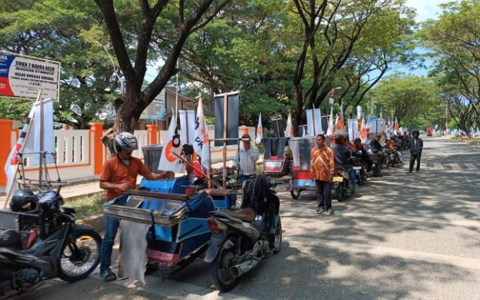 Salim Segaf PKS (1) Punya Idealisme, Orang Aceh Tidak Gampang Dibeli! Puluhan becak motor beratribut PKS berjejer saat menyambut kedatangan Ketua Majelis Syura PKS Salim Segaf ke Aceh di sepanjang jalan Sultan Malikussaleh, Lhong Raya, Banda Aceh, Minggu (14/1/2024). Foto: Komparatif.ID/Fuad Saputra.
