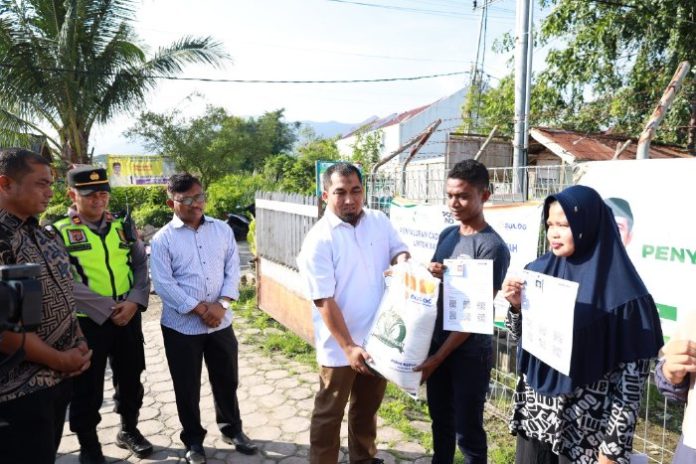 Pj Bupati Aceh Besar Muhammad Iswanto saat menyerahkan bantuan pangan tahun 2024 secara simbolis kepada 3.389 Keluarga Penerima Manfaat (KPM) di Kecamatan Darul Imarah. Foto: Ho for Komparatif.ID.