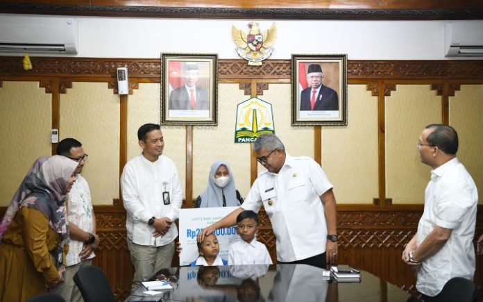 Pj Gubernur Bustami Puji Inovasi BPJS Ketenagakerjaan Pj Gubernur Aceh Bustami Hamzah saat menyerahkan santunan Jaminan Kematian kepada keluarga Almarhum Yusri Afifuddin, Jumat (22/3/2024). Foto: Ho for Komparatif.ID.
