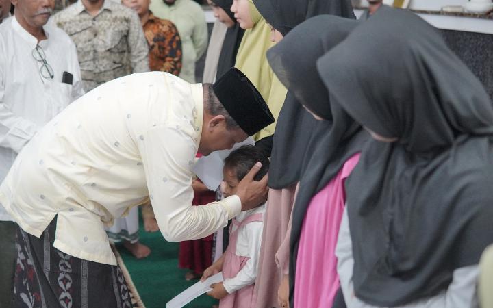 H. Mukhlis Takabeya menyerahkan santunan untuk 100 anak yatim di Masjid Syuhada Lapan di gampong Keude Tambue, Kecamatan Simpang Mamplam, Sabtu (30/3/2024).