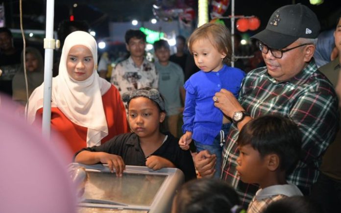 Ketika Bustami & Mellani Berbagi Kebahagiaan Untuk Anak-Anak di Singkil Pj Gubernur Aceh Bustami Hamzah dan Istri Mellani saat meninjau Pagelaran Hiburan Rakyat dan Bazar UMKM HUT Kabupaten Aceh Singkil ke-25, di Alun-Alun Kota Singkil, Sabtu (27/4/2024) malam. Foto: Ho for Komparatif.ID.