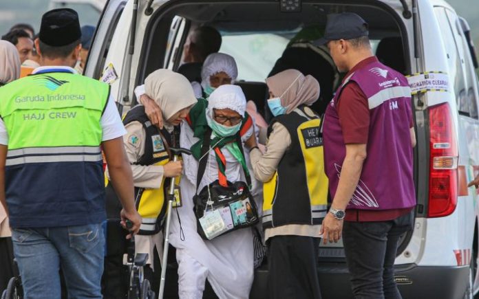 Kloter 2 Bireuen (1) Jemaah Haji Bireuen Mendarat di Jeddah Petugas membantu jemaah lansia kloter 2 di Bandara Internasional Sultan Iskandar Muda, Blang Bintang, Aceh Besar. Kamis (30/5/2024). Foto: Ho for Komparatif.ID.