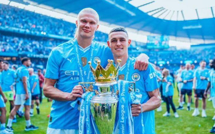 Man City Cetak Sejarah, Manchester City Raih Gelar Liga Inggris 4 Kali Berturut-turut Erling Haaland dan Phil Foden saat merayakan gelar Liga Inggris usai Manchester City membekuk West Ham 3-1 di Stadion Etihad, Minggu (19/5/2024). Foto: Manchester City.