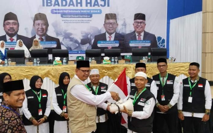 Kelelahan, Petugas Haji Aceh Meninggal di Mekkah PPIH Embarkasi Aceh Ahmad Yani serahkan perlengkapan kloter pada almarhum Manshur, Selasa (4/6/2024). Foto: PPIH Aceh.
