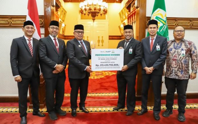 Penyerahan dividen simbolis Plt Direktur Utama Bank Aceh Fadhil Ilyas kepada Penjabat Gubernur Aceh Bustami Hamzah di Banda Aceh, Senin (22/7/2024). Foto: HO for Komparatif.ID.