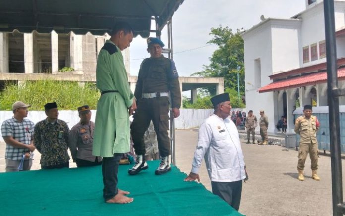 Cambuk di Pidie 7 Penjudi & 2 Pezina Dieksekusi Cambuk di Pidie 9 terpidana pelanggar Qanun Syariat Islam dicambuk di halaman Masjid Agung Al Falah, Kota Sigli, Jumat (26/7/2024). Foto: Komparatif.ID/Harmadi.
