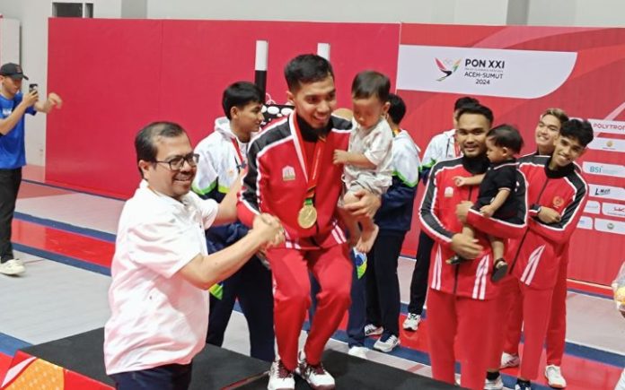 Tutup Karier Dengan Emas, Erwan Ingin Jadi Pelatih di Kampung Halaman Plh Sekda Aceh sekaligus Ketua Harian PB PON Wilayah Aceh Azwardi Abdullah saat mengalungkan medali kepada Erwan Tona yang memenangkan emas cabor anggar nomor floret beregu putra, Minggu (15/9/2024). Foto: Ho for Komparatif.ID.