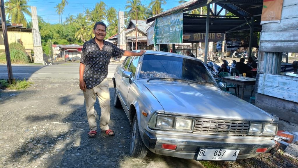 M. Nasir bersama Toyota Corona 1979 miliknya. Foto: Komparatif.ID/Muhajir Juli.
