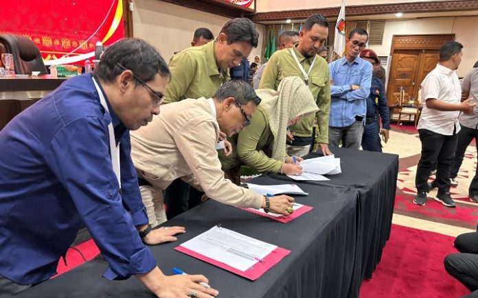 KIP Aceh Tim Bustami-Fadhil Rahmi Tolak Hasil Rekapitulasi Pilgub Aceh 2024 , Rekapitulasi Selesai, Mualem-Dek Fadh Menangi Pilgub Aceh 2024 Komisioner KIP Aceh saat menandatangani hasil rekapitulasi hasil perolehan suara Pilgub Aceh 2024 di ruang paripurna DPRA, Minggu, (8/12/2024). Foto: Komparatif.ID/Fuad Saputra.