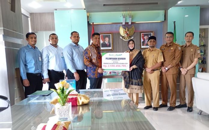 Dividen Bank Aceh Banda Aceh Dapat Dividen Rp2,5 miliar dari Bank Aceh Pemimpin Bank Aceh Kantor Cabang Utama Bank Aceh, Andri Wardani menyerahkan secara simbolis dividen Bank Aceh Syariah Tahun Buku 2024 kepada Wali Kota Banda Aceh, Illiza Sa’aduddin Djamal. Foto: HO for Komparatif.ID.