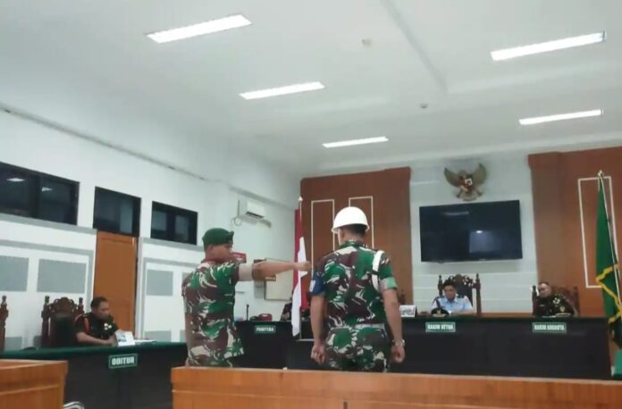 Pratu Shaifonna Fadhil (berdiri, kiri) Senin (10/11/2025) di ruang sidang Pengadilan Militer Medan. Foto: Tribunnews.