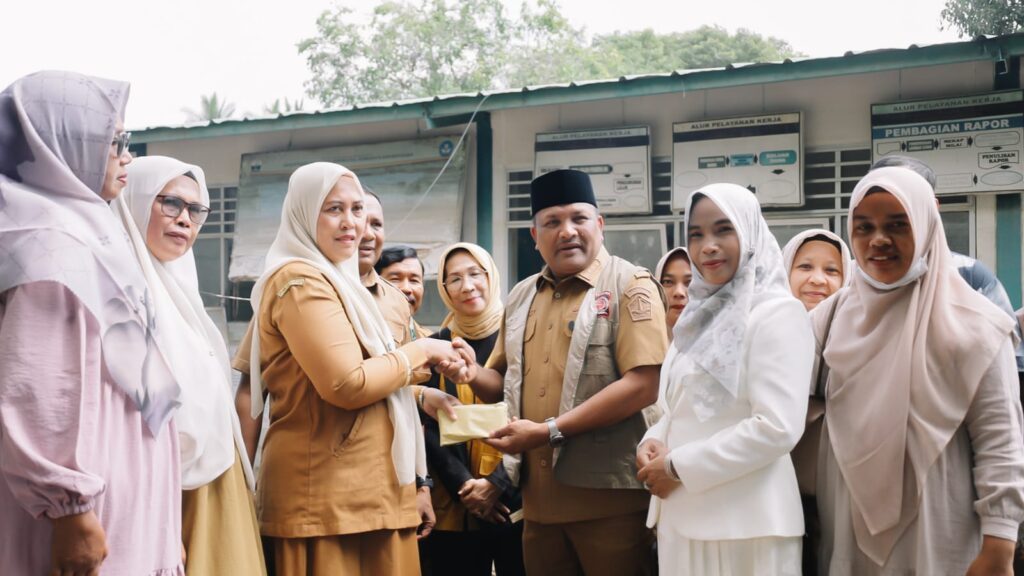 Bupati Bireuen, H. Mukhlis ST, bersama Bunda PAUD Bireuen, Sadriah Mukhlis, didampingi Kadisdikbud Bireuen, Muslim, menyerahkan bantuan uang tunai untuk pembersihan sekolah. Foto: HO for Komparatif.ID.