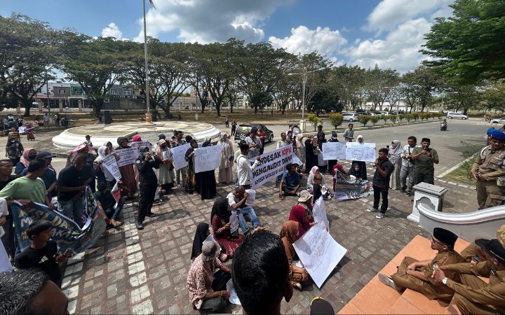 Puluhan pengungsi bersama elemen masyarakat sipil bertemu Pj Sekda Bireuen, Hanafiah, dan Asisten II Setdakab Bireuen, Mawardi, saat aksi unjuk rasa di Kantor Bupati Bireuen, Senin (16/3/2026). Foto: Komparatif.ID/Fuad Saputra.
