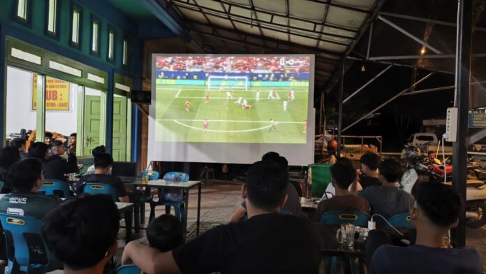 Ronaldo Cetak Brace, Warkop di Banda Aceh Bergemuruh Dukung Portugal Komparatif.ID, Banda Aceh– Antusiasme tinggi ditunjukkan para pendukung Portugal yang menyaksikan pertandingan melawan Uzbekistan di Warkop Atalanta Premium, Ulee Kareng, Banda Aceh, Rabu (24/6/2026). Warung kopi tersebut dipenuhi penonton dari berbagai kalangan usia yang sama-sama memeriahkan pesta sepak bola empat tahunan itu. Sejak pertandingan dimulai, suasana di lokasi sudah ramai. Anak-anak yang datang bersama orang tuanya tampak ikut menyaksikan aksi Cristiano Ronaldo, sementara kalangan anak muda mendominasi jumlah penonton. Tidak sedikit pula para bapak-bapak yang masih antusias mengikuti jalannya pertandingan.